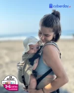 madre con bebe en portabebe ergonomico en playa de mexico