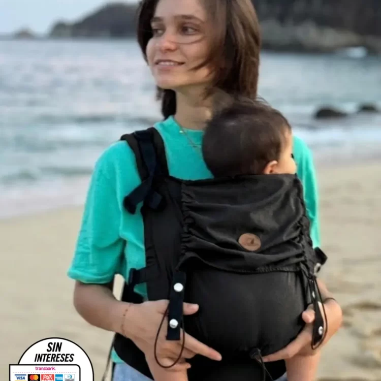 mama-pasea-junto-a-bebe-en-portabebes-ergonomico-en-playa-mexico